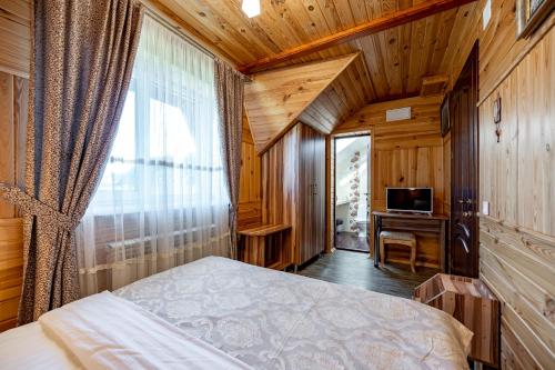 a bedroom with a bed and a desk and a television at Emerald House in Mykulychyn