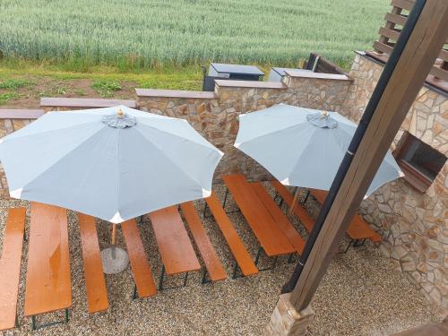 two white umbrellas are sitting on a bench at Penzion u Pinkasů s wellness in Jablunkov