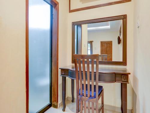 a mirror in a room with a wooden table and a chair at OYO 1762 Hotel Astiti Graha Tanah Lot in Tanah Lot