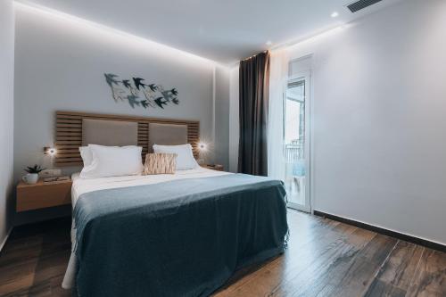 a bedroom with a large bed and a large window at Seascape Luxury Residences in Agia Pelagia