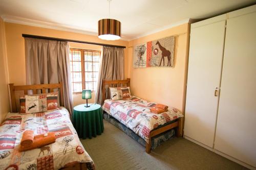 a bedroom with two twin beds and a window at Sneezewood in Dullstroom