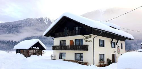 ein schneebedecktes Gebäude mit Bergen im Hintergrund in der Unterkunft Guesthouse Schoba Typ A in Kirchbach