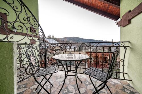 a patio with a table and chairs on a balcony at Emerald House in Mykulychyn