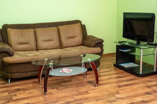 a living room with a couch and a table and a tv at Zakarpatskiy Oazis in Karpaty
