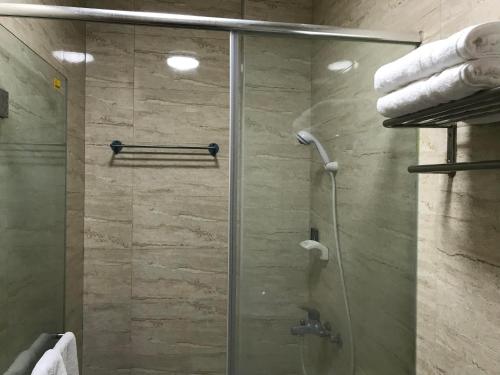 a shower with a glass door in a bathroom at Taitung Tourist Inn in Taitung City
