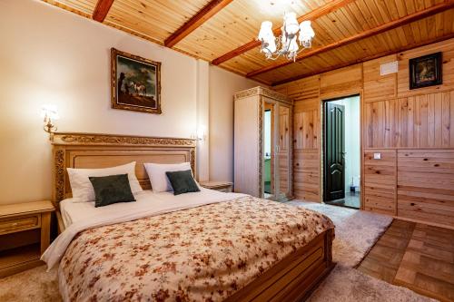 a bedroom with a large bed and a wooden ceiling at Emerald House in Mykulychyn