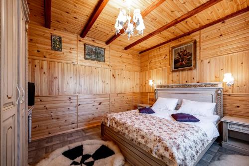 a bedroom with a bed in a wooden room at Emerald House in Mykulychyn