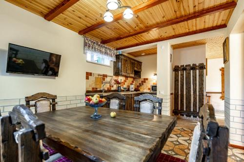 a dining room with a wooden table with a bowl of fruit on it at Emerald House in Mykulychyn