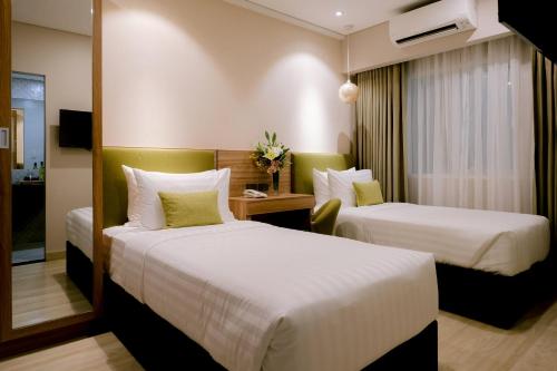 a hotel room with two beds and a television at Goldberry Suites and Hotel Cebu in Cebu City