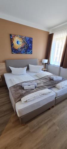 a bedroom with two large beds and a painting on the wall at Pension am Stern in Leipzig