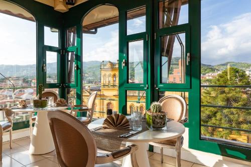 a restaurant with tables and chairs and large windows at Hotel Columbia Wellness & Spa in Montecatini Terme