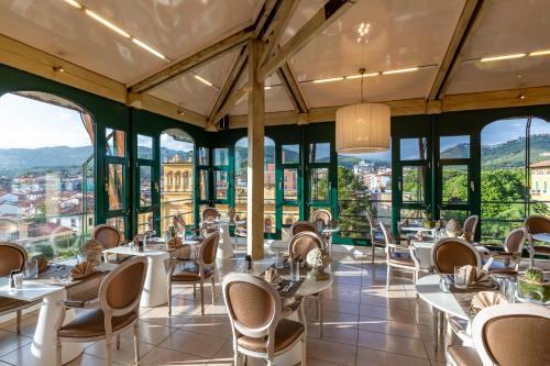 a restaurant with tables and chairs and windows at Hotel Columbia Wellness & Spa in Montecatini Terme