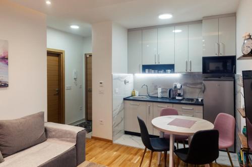 uma cozinha e uma sala de estar com uma mesa e um sofá em Per silvas apartman i spa em Zlatibor