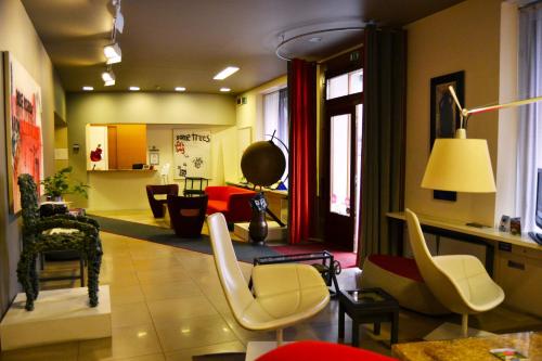 a living room with a bunch of chairs and tables at Hotel Colombia in Trieste