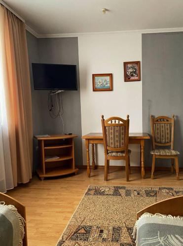 a living room with a table and chairs and a television at Lemon in Drohobytsch
