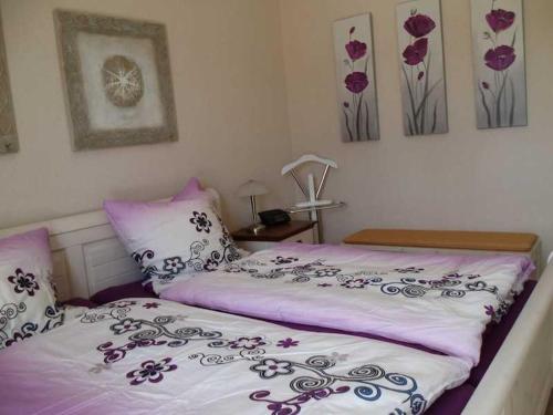 a bedroom with a bed with purple and white sheets at Ferienhaus _ Sonnenschein in Gülden