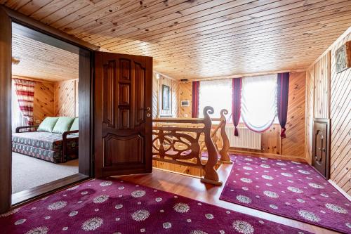 a room with a bed and a door and a rug at Emerald House in Mykulychyn