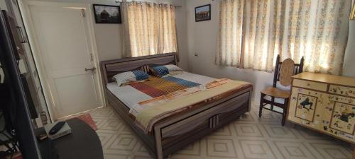 1 dormitorio pequeño con 1 cama y 1 silla en ''Go Desert'' Homestay, en Bhuj