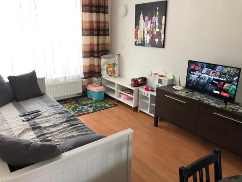 uma sala de estar com um sofá e uma televisão de ecrã plano em Rekreace na Lipně em Frymburk