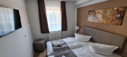 a small room with a bed and a window at Pension am Stern in Leipzig