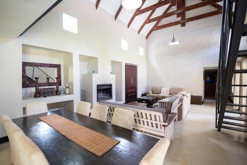 a living room with a dining table and a fireplace at Sorgenvrei in Dullstroom