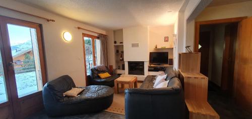 ein Wohnzimmer mit 2 Stühlen und einem TV in der Unterkunft Mont Bijou MOUNTAIN & QUIET chalet 10 pers by Alpvision Résidences in Veysonnaz
