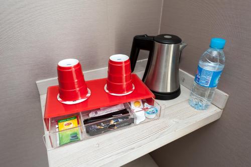a table with a red tray with cups and water at Hôtel le 209 Paris Bercy in Paris