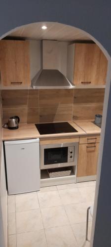 une cuisine avec des armoires en bois et un four à plaques de cuisson dans l'établissement Très belle Appartement F1 bis, à Perpignan