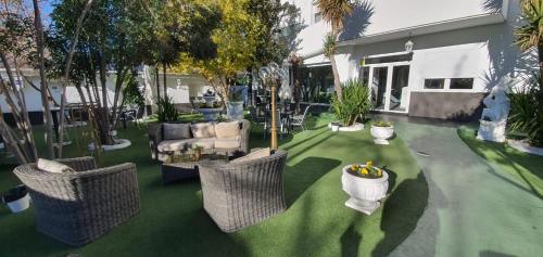 a garden with chairs and a couch and trees at Escala Suites in Madrid