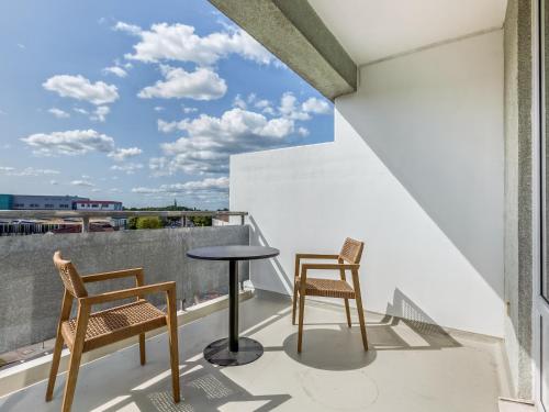 einen Balkon mit 2 Stühlen und einem Tisch in der Unterkunft limehome Wolfsburg Porschestraße in Wolfsburg