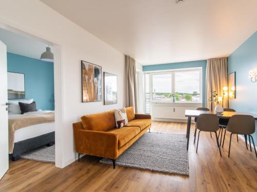 a bedroom with a bed and a couch and a table at Limehome Wolfsburg Porschestraße in Wolfsburg