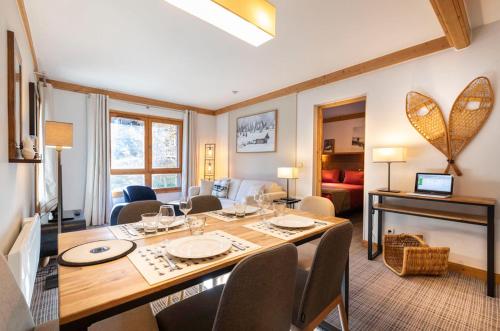 une salle à manger avec une table et un salon dans l'établissement Arc 1950 Appartement 4 personnes Ski aux pieds, à Arc 1950