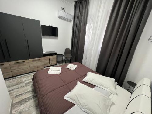 a hotel room with a bed and a flat screen tv at Pensiunea Luisa in Craiova