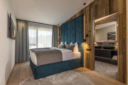 a bedroom with a large bed and a mirror at Perfect Lodgings Panorama in Hart im Zillertal