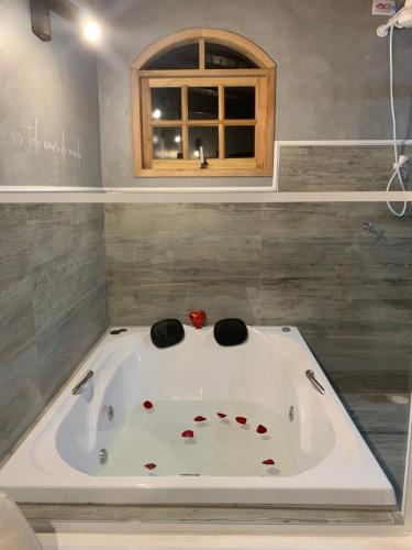 a bath tub in a bathroom with a window at Chales em Salesopolis - Recanto da Barra in Salesópolis