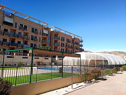 a building with a swimming pool in front of a building at Apartamento en puerta valle Ricote y Archena in Villanueva de Río Segura