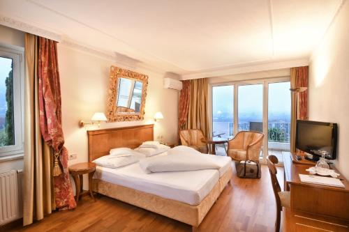 a hotel room with a large bed and a television at Hotel MARIA THERESIA adults-only in Lagundo