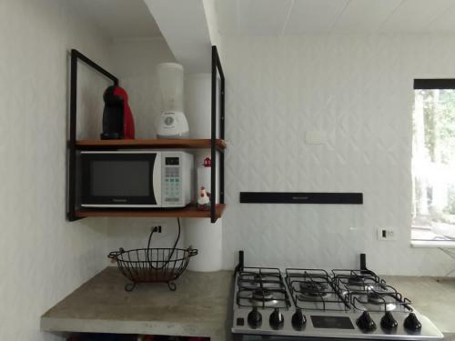 a kitchen with a stove and a microwave at Casa 62 Ilhabela in Ilhabela