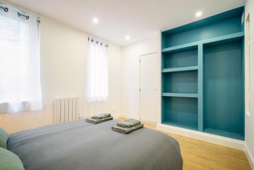 a bedroom with a large bed with blue shelves at Superbe appartement plein centre, calme, Netflix in Mirepoix