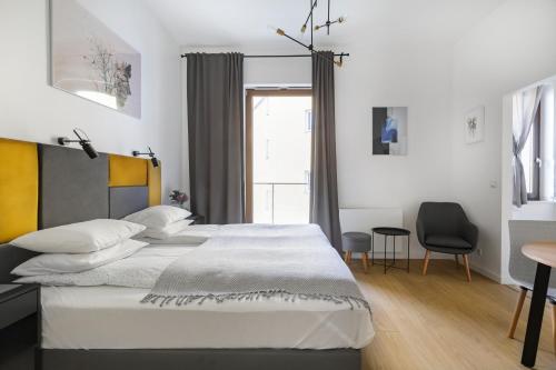 a bedroom with a bed and a table and a chair at Homewell Apartments Żelazko in Poznań