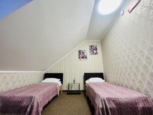 two beds sitting in a room with a attic at Готель Лаванда in Khmelʼnytsʼkyy