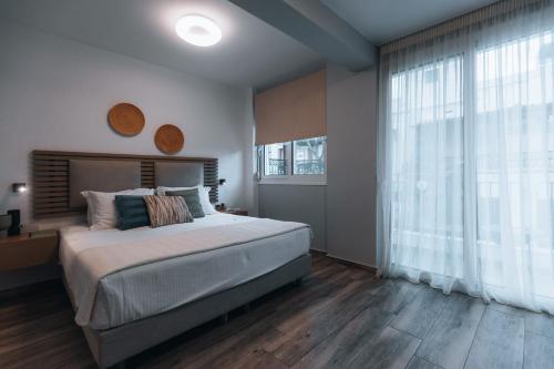a bedroom with a large bed and a large window at Seascape Luxury Residences in Agia Pelagia