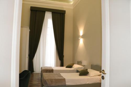 卡塔尼亞的住宿－DOMUS IOLE appartamento nel centro storico，酒店客房设有两张床和窗户。