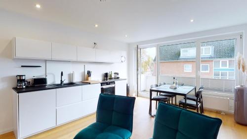 a kitchen and dining room with a table and chairs at Ferienwohnung 3-Zimmer, 70 qm 3 Minuten zum Strand und Zentrum WHG Timme 3 in Timmendorfer Strand