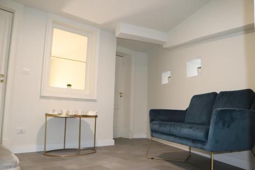 a living room with a blue couch and a table at DOMUS IOLE appartamento nel centro storico in Catania