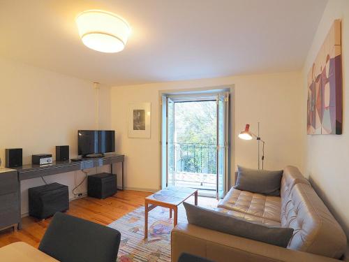 a living room with a couch and a tv at Bela Vista - Lissabon Altstadt in Lisbon