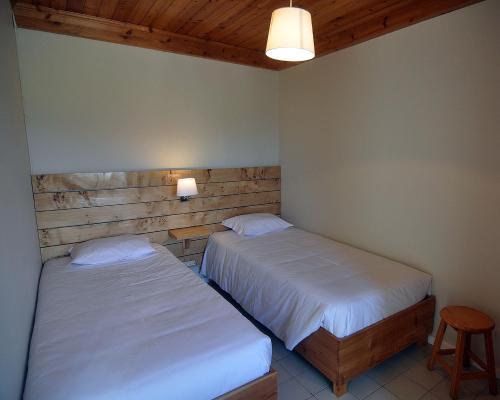 a bedroom with two beds and a table and a stool at Casa da Praya in Horta