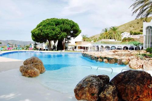 una piscina con rocas en el agua en Beautiful apartment with amazing Sea view, en Nerja