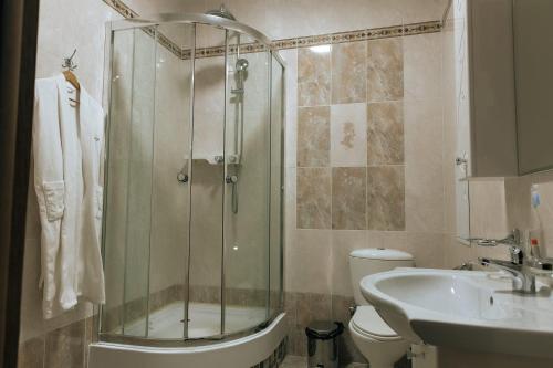 a bathroom with a shower and a toilet and a sink at Medeu in Kostanay