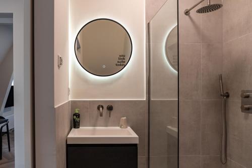 a bathroom with a sink and a mirror at Limehome The Hague Keizerstraat in Scheveningen